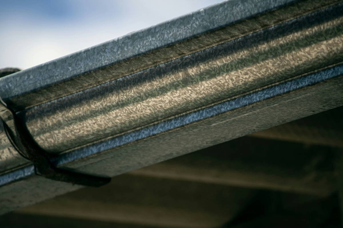 Close-up of magnetic roof clip holding string lights on sloped roof without damage