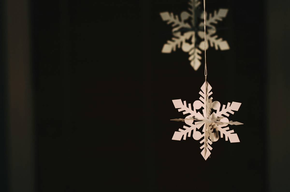 Styled Christmas tree featuring multiple beaded snowflake hooks coordinating silver and iridescent ornaments