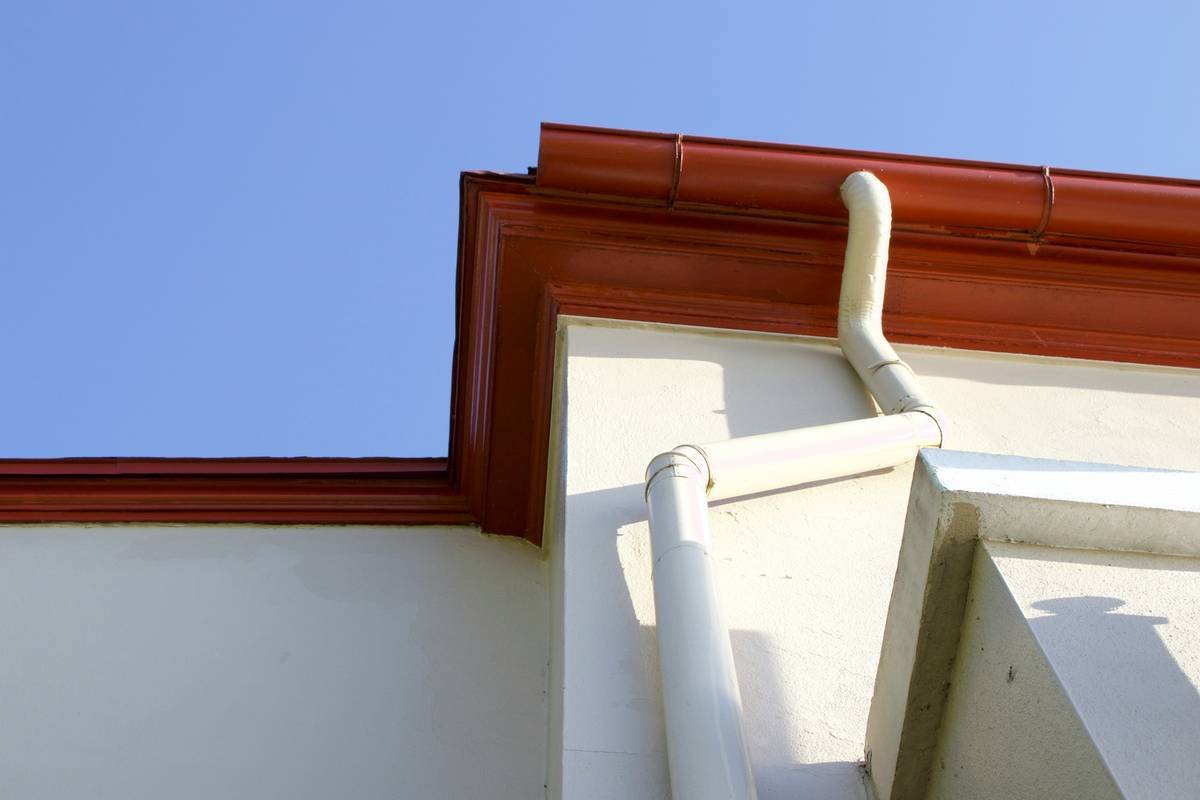 Close-up of gutter clip c7 securing C7 bulb strand to gutter edge during rainy UK winter