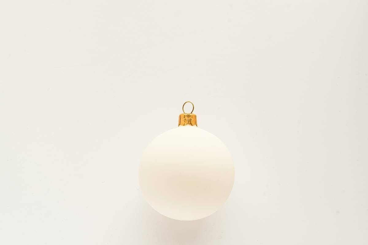 Close-up of matte finish ornament in earthy tones on a natural pine Christmas tree