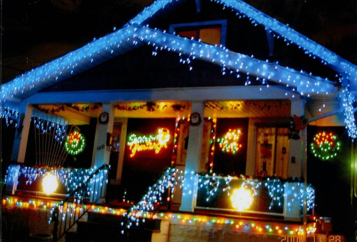 projector light show casting animated snowflakes onto a snowy front yard