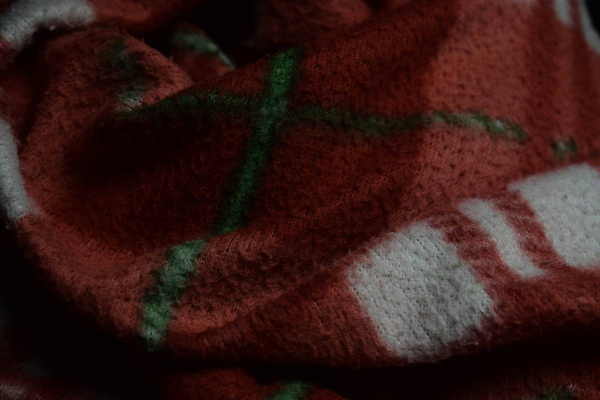 Close-up of embroidered cuff on a red velvet Christmas stocking with gold thread detailing